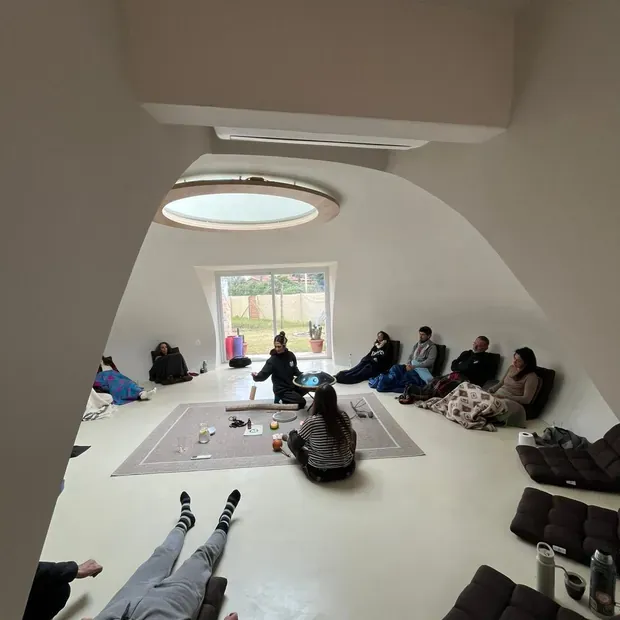 Círculo de personas en una jornada presencial, con instrumentos de sonido.